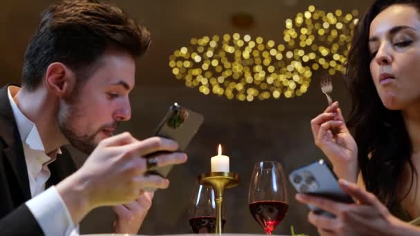 在餐厅吃饭的时候 男人和女人一边看手机屏幕一边吃沙拉 生活方式 关系的概念 慢动作 — 图库视频影像