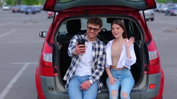 Romantyczna Para Siedząca Bagażniku Pozująca Przed Kamerą Smartfona Machająca Rękami — Wideo stockowe