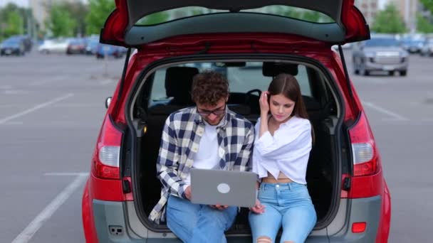 Щасливі Молоді Люди Сидять Багажнику Автомобіля Відкритому Повітрі Використовуючи Ноутбук — стокове відео
