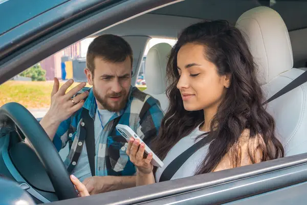 在驾驶课上 男教师对拿着手机的女士说脏话 并在车上看信息 驾驶考试 驾驶课程 考试概念 — 图库照片