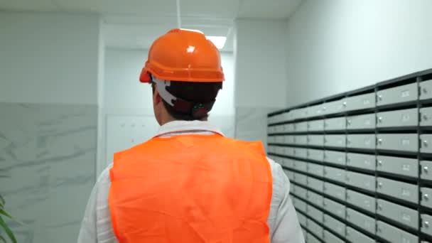 建設現場の建物内を歩くハードハットとウエストコートの男性ビルダー ビジネス ビルディング 産業コンセプト スローモーション — ストック動画
