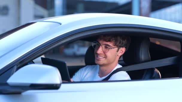 デジタルタブレットを使用している間 車のシートベルトを使用して幸せな男 タイピング ライフスタイルのコンセプト スローモーション — ストック動画