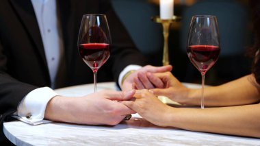 Lokantada romantik bir buluşma yaşarken kadının elini tutan adam, doğranmış, yakın plan. Yaşam tarzı, aşk, ilişkiler. Yavaş çekim