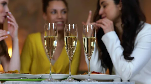 Lächelnde Junge Freundinnen Stoßen Restaurant Mit Champagner Und Unterhalten Sich — Stockfoto