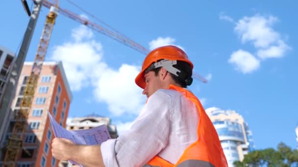 建設現場で作業中に屋外の建設図面を見ている男性ビルダー ビジネス ビルディング 産業コンセプト スローモーション — ストック動画