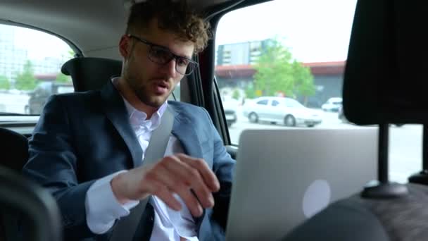 年轻的商人坐在后座出租汽车里 辛苦工作后关闭了笔记本电脑 运输和技术概念 慢动作 — 图库视频影像