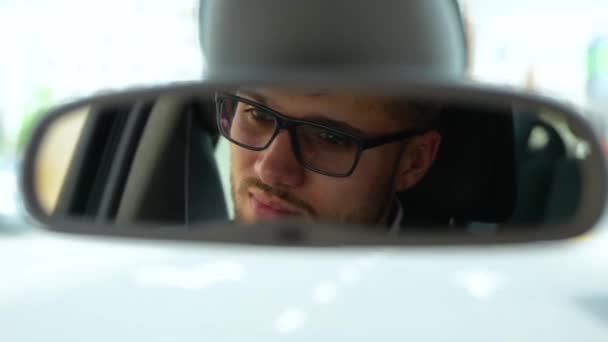 Jovem Satisfeito Usando Óculos Olhando Para Espelho Retrovisor Enquanto Dirige — Vídeo de Stock