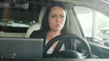 Genç bir kadın şehirde bir yayaya jest yaparken arabada oturup küfür ediyor. Güvenli sürüş, ulaşım, seyahat, iş konsepti. Yavaş çekim