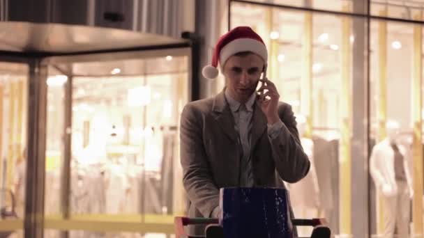 Lachende Man Kerstman Hoed Met Winkelwagentje Supermarkt Achtergrond Praten Smartphone — Stockvideo
