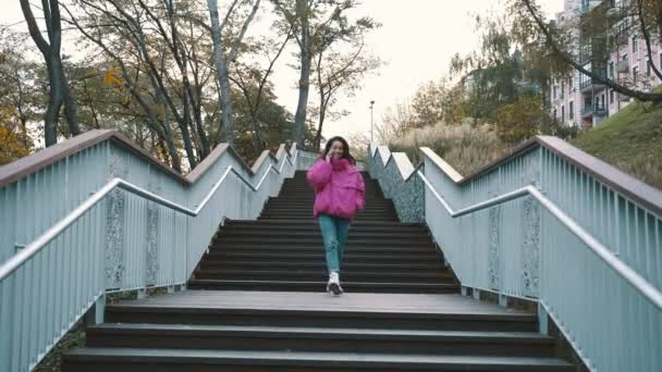 Elegante Dama Sonriente Chaqueta Rosa Bajando Las Escaleras Parque Ciudad — Vídeo de stock