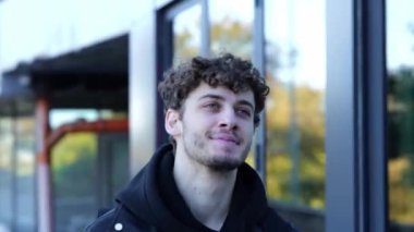 Arka planda bina olan sırt çantalı, memnun ve şık bir adam. Sonbahar yürüyüşü kavramı. Gerçek zamanlı konsept.