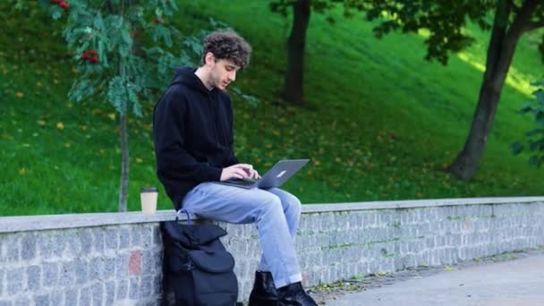 Stilvoller Typ Der Mit Laptop Arbeitet Während Mit Kaffee Park — Stockvideo