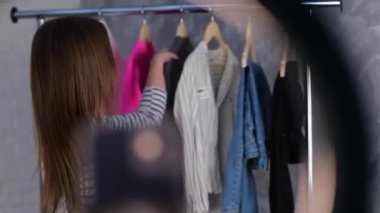 Mutlu güzel bayan kameraya gri süveterini gösterirken evde internetten gelen kıyafetlerin reklamını yapıyor. Stilist etkileyicisi video blogu çekiyor. Küçük işletme, çevrimiçi pazar konsepti. - Evet. Gerçek zamanlı video.