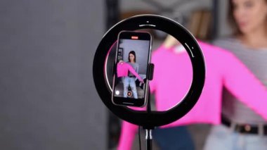 Cep telefonu ekranı kayıt bloğunun görüntüsü. Kadın blogcu takipçilerine pembe kazak gösteriyor. İnternet günlüğü konsepti. - Evet. Gerçek zamanlı video.