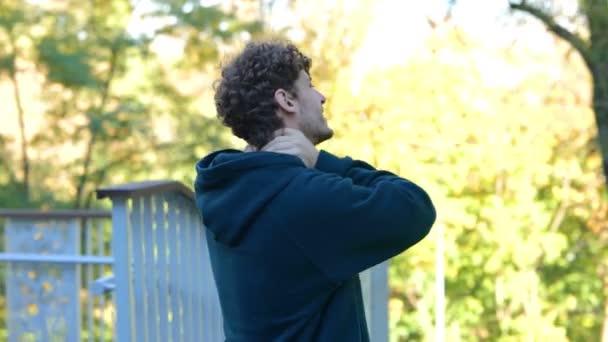 Achteraanzicht Jonge Blanke Man Masseert Zijn Nek Het Groene Park — Stockvideo