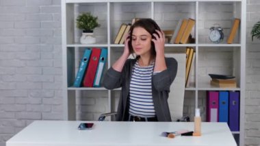 Telsiz kulaklıkla müzik dinleyen çekici, genç esmer bayan cep telefonu kullanıyor, eğleniyor ve dans ediyor. Yaşam tarzı konsepti. Gerçek zamanlı konsept.