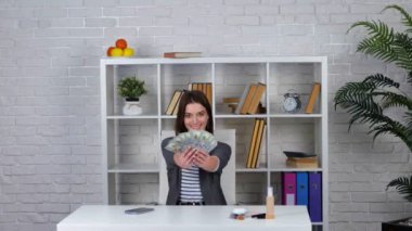 Gülümseyen kadın blogcu para kusuyor. Güzel bayan para saçarak karı kutluyor. İş konsepti. - Evet. Gerçek zamanlı video.