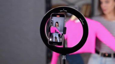 Cep telefonu ekranı kayıt bloğunun görüntüsü. Kadın blogcu takipçilerine pembe kazak gösteriyor. İnternet günlüğü konsepti. - Evet. Gerçek zamanlı video.