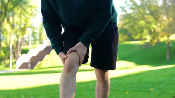 Giovane Uomo Massaggiare Ginocchio Muscoli Prima Lavorare Fuori Nel Parco — Video Stock