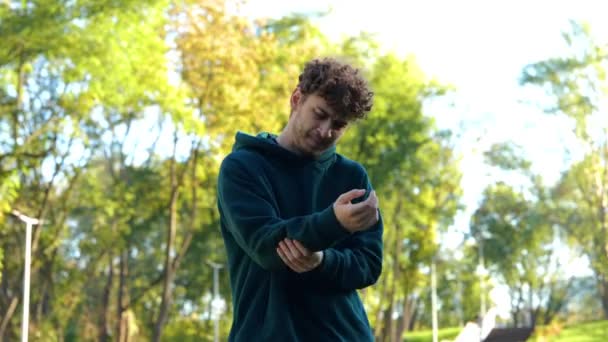 Homem Caucasiano Jovem Correndo Parque Entre Árvores Verdes Sentindo Braço — Vídeo de Stock