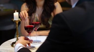 Romantik bir buluşma yaşarken ve elinde kırmızı şarapla bir adama bakan güzel bir bayan. Yaşam tarzı, aşk, ilişkiler. Gerçek zamanlı video.