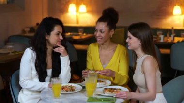 Restoranda oturmuş bruschetta yerken kokteyllerle dinlenen mutlu güzel kadınlar. Arkadaşlarla buluşacağız. Yaşam tarzı, arkadaşlık kavramı. Gerçek zamanlı video.