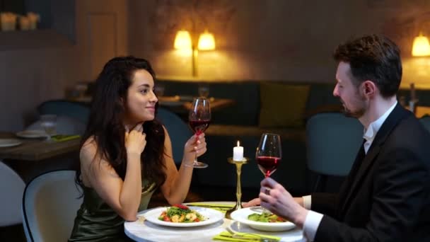 笑顔のロマンチックなカップルは レストランでデートを楽しんでいる間 ワイングラスでクライミング ライフスタイル 人間関係の概念 リアルタイムビデオ — ストック動画