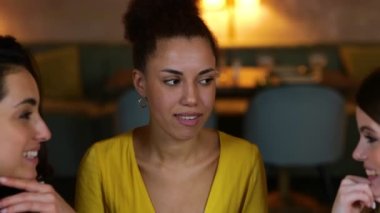 Afro-Amerikalı bir kadın bir restoranda şampanya içerken arkadaşlarına alyansını gösteriyor. Arkadaşlarla buluşacağız. Yaşam tarzı, arkadaşlık kavramı. Gerçek zamanlı video.