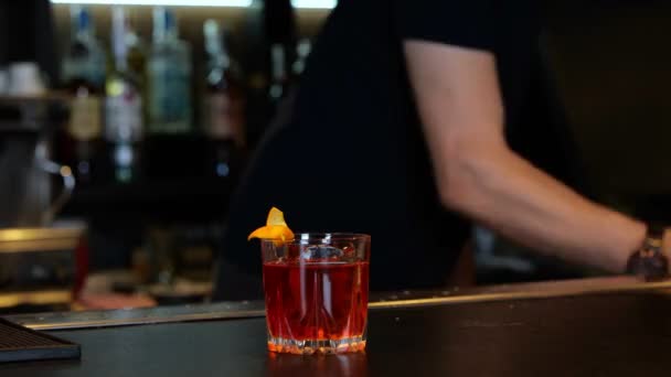 Barkeeper Bereitet Cocktail Mit Großen Eiswürfeln Und Orangenschale Auf Der — Stockvideo