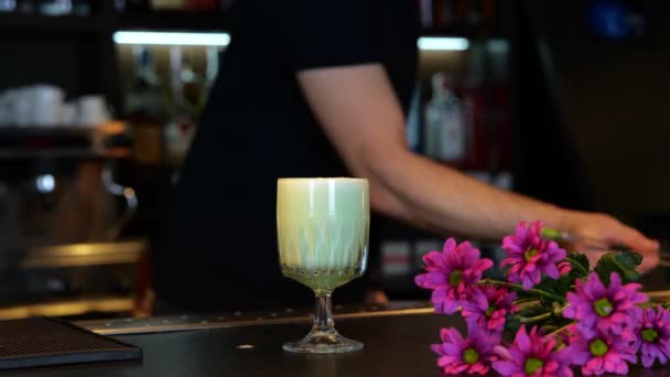 美しい花でカクテルを飾るバーマン バーカウンターで美味しいアルコール飲料 クロップした リアルタイム — ストック動画