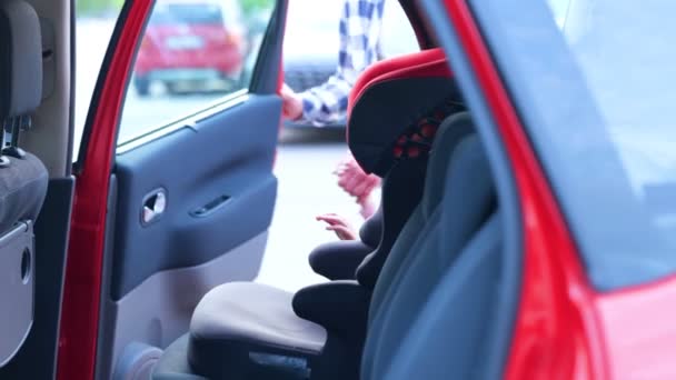Genç Adam Küçük Kızı Arabanın Arka Koltuğunda Emniyet Kemeriyle Bağlıyor — Stok video