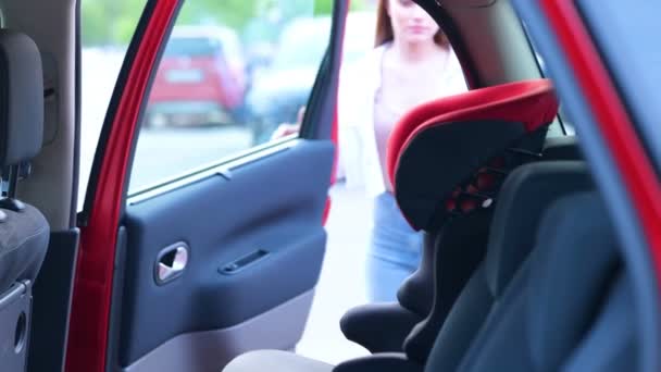 Young Mother Helping Her Daughter Sitting Car Seat While Fastening — Stock Video