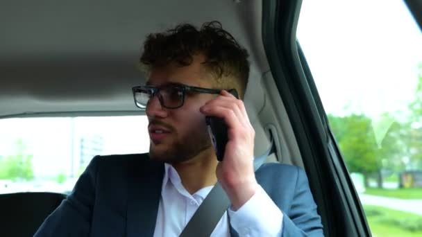 笑顔のビジネスマンはタクシー車で働き 携帯電話で話しながら後部座席に座りました ビジネス 技術コンセプト リアルタイム — ストック動画