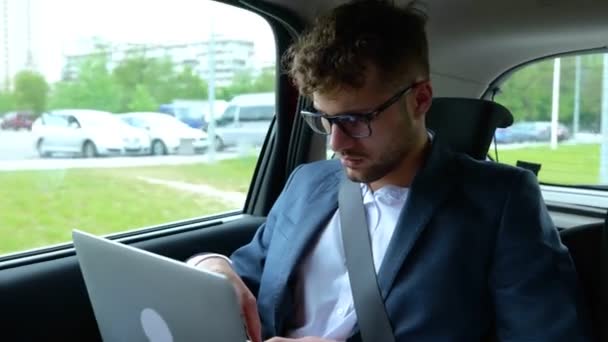 旅行中にオンラインで作業しながら ラップトップを使用してタクシー車の後部座席に座っている男性 ビジネス 技術コンセプト リアルタイム — ストック動画