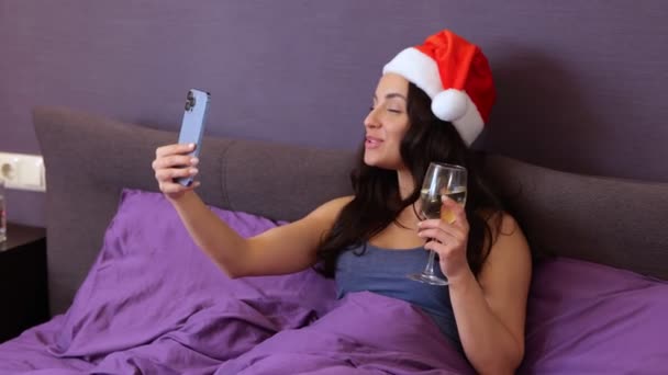 圣诞节假期里 用智能手机打电话聊天 一边在网上聊天 一边拿着香槟 一边笑着漂亮的女人 圣诞节网上祝贺 慢动作 — 图库视频影像