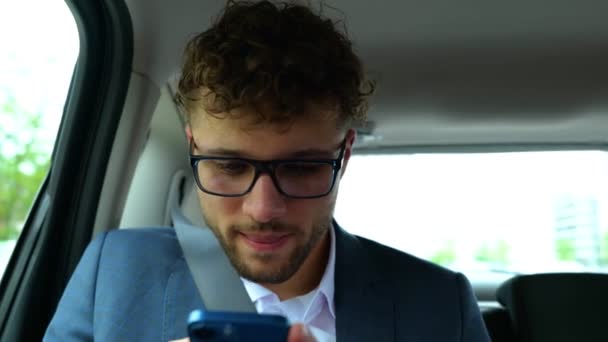 快乐的年轻商人坐在汽车后座上 用手机和打字留言 运输和技术概念 — 图库视频影像
