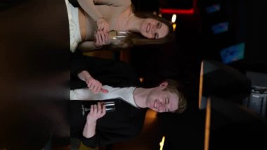 Gece kulübünde şampanya içerken eğlenen gülümseyen çift. Yaşam tarzı, parti, dikey, sosyal ağlar konsepti. Gerçek zamanlı..