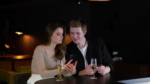 Улыбающаяся Леди Показывает Телефон Своему Другу Мужчине Наслаждаясь Вечером Ресторане — стоковое видео