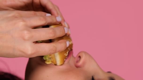 Позитивна Жінка Позує Студії Кусаючи Гамбургер Копіювати Простір Крупним Планом — стокове відео