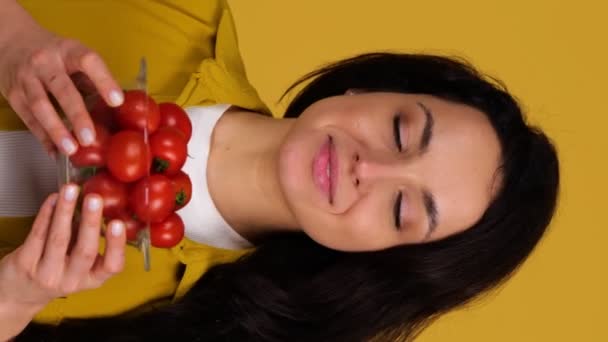 Jovencita Sonriente Demostrando Tomates Cherry Mientras Está Pie Sobre Fondo — Vídeos de Stock