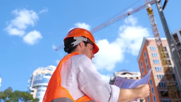 Чоловік Будівельник Дивиться Будівельні Креслення Відкритому Повітрі Під Час Роботи — стокове відео