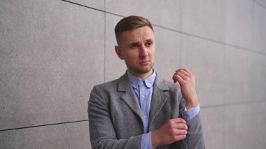 Gülümseyen genç iş adamı bir iş toplantısına gidiyor, dışarıda duruyor. İş, iş kavramı. Yavaş çekim