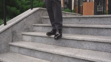 İş adamı şehrin dışındaki merdivenlerden iniyor. Kırpılmış. İş, insanların kavramı. Yavaş çekim