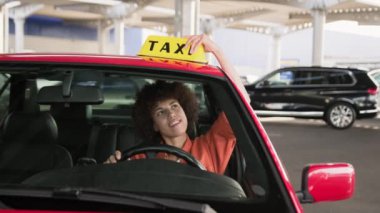 Afro-Amerikalı taksi şoförü, baş parmağını gösterirken sarı taksi arabası tabelası kullanıyor. İnsanlar, iş, hizmet kavramı. Yavaş çekim