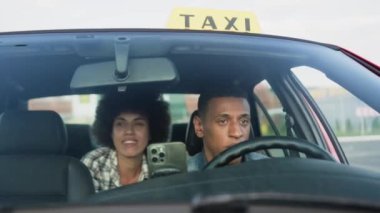Arabada arka koltukta oturan genç bayan taksi şoförüyle konuşuyor. Sarı taksi arabası tabelası. İnsanlar, iş, hizmet kavramı. Yavaş çekim