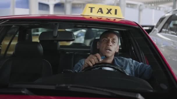 若いタクシー運転手が市内で車を運転しながら電子タバコを吸っている 健康の概念 スローモーション — ストック動画