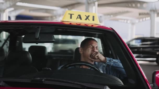 疲れた男性のタクシー運転手が車の中でコーヒーを飲んでいる間に溺れています 黄色いタクシー車の屋根サイン サービスコンセプト スローモーション — ストック動画