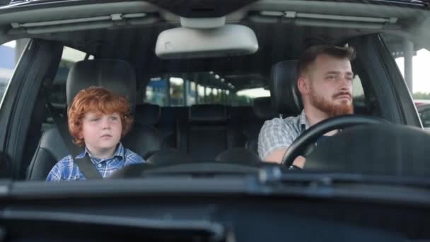 Молодий Чоловік Водить Машину Поки Маленький Хлопчик Сидить Пасажирському Сидінні — стокове відео