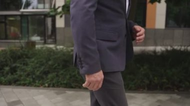 Sokakta yürüyen mutlu stil sahibi bir iş adamı. İş, iş, insan konsepti. Yavaş çekim