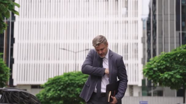 ラップトップとノートを持ちながら通りを歩いている大人の男 ビジネス 人々のコンセプト スローモーション — ストック動画